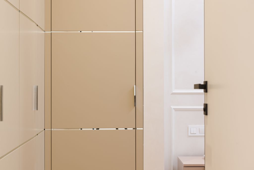 Beige colored doors and wardrobe in hallway of contemporary apartment with minimalist design
